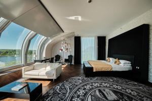 a bedroom with a large bed and a large window at Kameha Grand Bonn in Bonn