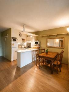 a kitchen and dining room with a wooden table at Montana Family Nature in Enveitg