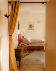 a bedroom with a bed and a chair in a room at Fliederhof Stücken Apartments bei Potsdam in Michendorf