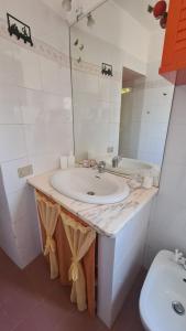 a bathroom with a sink and a mirror and a toilet at Casa Clelia e Aida in Roccatederighi