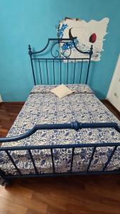 a bed in a room with a blue wall at Casa Clelia e Aida in Roccatederighi +6 photos