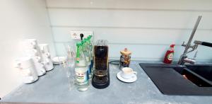 a counter with bottles and cups and a sink at Helles Zimmer im Loft in Mannheim +7 photos