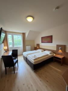a large bedroom with a large bed and a desk at Hotel & Restaurant Brühler Hof in Wintrich