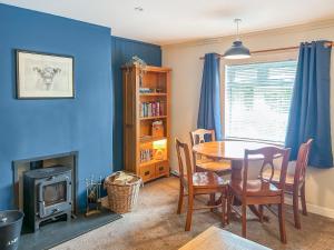 a dining room with a table and a wood stove at Broom Cottage in Newtonmore