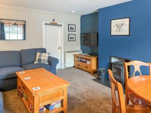 a living room with a couch and a table at Broom Cottage in Newtonmore