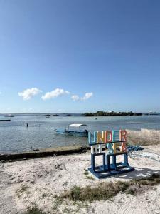 a bench sitting on a beach next to a body of water at Under the sea diving resort in Lapu Lapu City