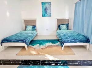 two beds in a room with blue sheets at Under the sea diving resort in Lapu Lapu City