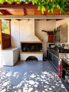 an outdoor kitchen with a fireplace in the middle at Yfantis Sakis Apartment's in Erateini