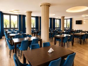 a restaurant with wooden tables and blue chairs at Boutique Hotel's Kwiska - Legnicka in Wrocław