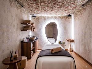 a bedroom with a bed in a room with a mirror at Swissôtel Tbilisi in Tbilisi City