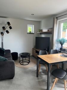 a living room with a couch and a table and a tv at Ferienhaus Friedrich 22 in Kolkwitz