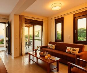 a living room with a couch and a table at Seaside Getaway - Aelia Villa's Dreamy Paradise in Petalidi