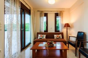 a living room with a couch and a table at Seaside Getaway - Aelia Villa's Dreamy Paradise in Petalidi
