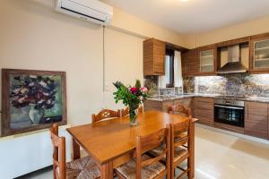a kitchen with a wooden table with a vase of flowers on it at Seaside Getaway - Aelia Villa's Dreamy Paradise in Petalidi