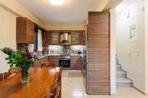 a kitchen with a wooden table and a refrigerator at Seaside Getaway - Aelia Villa's Dreamy Paradise in Petalidi +28 photos