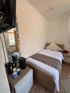 a small bedroom with a bed and a television at Baden-Baden Zentrum Studio in Baden-Baden