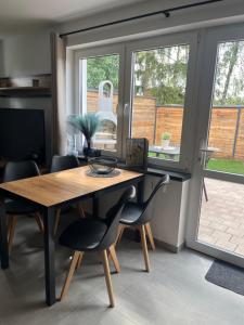a dining room with a table and chairs and a window at Ferienhaus Friedrich 22 in Kolkwitz +8 photos