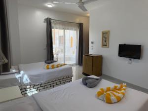 a room with two beds and a television in it at Pharaohs Guest House in Luxor