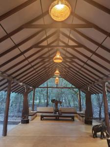a large room with a large wooden ceiling with lights at Kaala Kalaththewa Luxury Eco Resort in Anuradhapura