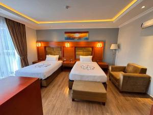 a hotel room with two beds and a chair at 2RN SOLOMON Hotel and Spa 