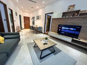 a living room with a couch and a tv at Sky Apart-Hotel klcc in Kuala Lumpur