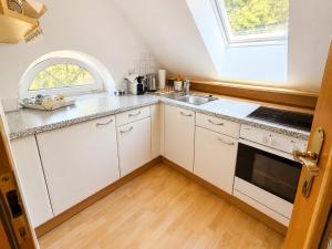 a kitchen with white cabinets and a window at Schlossapartments Wolfsberg in Wolfsberg