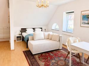 a bedroom with a bed and a couch and a chair at Schlossapartments Wolfsberg in Wolfsberg
