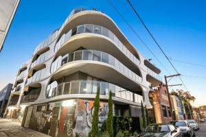 a white building on the side of a street at District Apartments Fitzroy in Melbourne