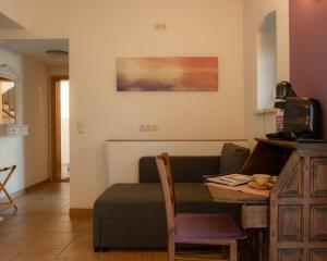 a living room with a table and a couch at Fliederhof Stücken Apartments bei Potsdam in Michendorf