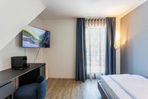 a hotel room with a bed and a desk and a television at Osteria Ascona in Ascona +13 photos