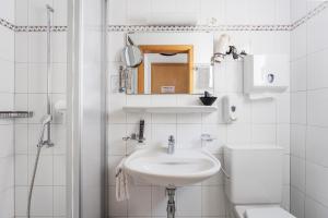 a white bathroom with a sink and a toilet at Osteria Ascona in Ascona