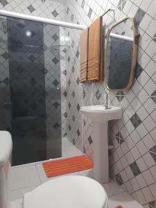 a bathroom with a sink and a shower with a mirror at Hostel Família Carvalho in Barreirinhas