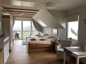 a bedroom with a large bed and a balcony at Marbijes Appartementhaus in Cuxhaven