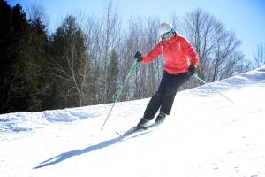 
a person riding skis down a snow covered slope at Sir Sam's Inn & Spa in Haliburton
