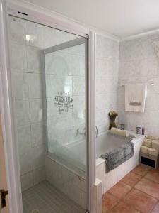 a bathroom with a bath tub and a shower stall at De Kleine Herberg in Durbanville