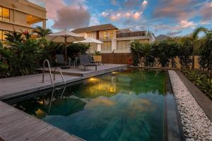 a swimming pool in front of a house at NEW Beachfront 3-bedrooms Apartment in Tamarin, Ocean Legend in Tamarin