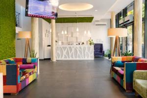 a lobby with colorful chairs and a counter at Boutique Hotel's Kwiska - Legnicka in Wrocław