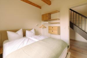 a bedroom with a white bed and a dresser at Eldehaus Plau am See klimatisiert in Plau am See