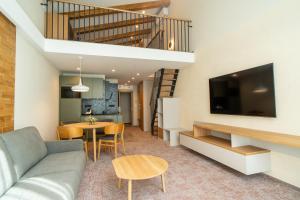 a living room with a couch and a table at APLEND Aparthotel Litvor in Štrba