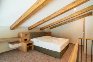 a bedroom with a bed in a loft at APLEND Aparthotel Litvor in Štrba