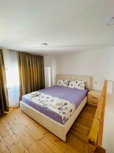 a bedroom with a large bed with purple sheets at Vila Francesko in Ksamil