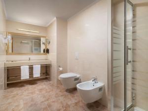 a bathroom with a toilet and a sink and a shower at Mercure Chisinau Center Jazz Hotel in Chişinău