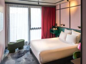 a bedroom with a large bed and a red curtain at TRIBE Lyon Croix Rousse in Lyon