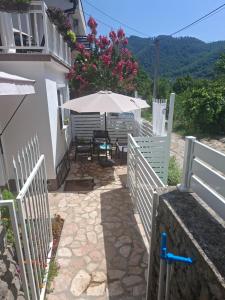 a patio with a table and an umbrella at Studio apartman NN - Boračko jezero in Konjic