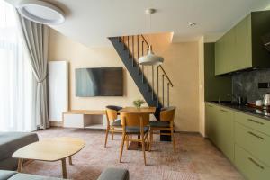 a kitchen and dining room with a table and chairs at APLEND Aparthotel Litvor in Štrba
