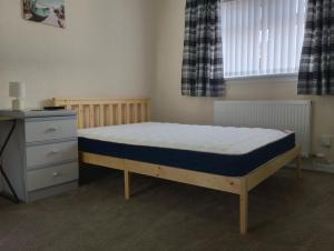 a small bedroom with a bed and a dresser at Studio Twenty One in Whitburn