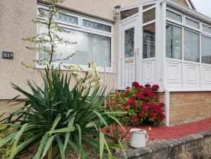 a front door of a house with flowers at Studio Twenty One in Whitburn