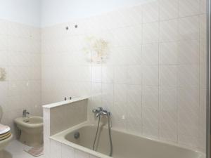a white bathroom with a tub and a toilet at Unit 120 in SantʼAgata di Militello