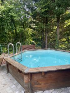 a large pool with a wooden deck around it at Studio cosy avec piscine privative in Saint-Sernin