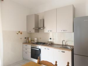 a small kitchen with white cabinets and a sink at Unit 120 in SantʼAgata di Militello +36 photos